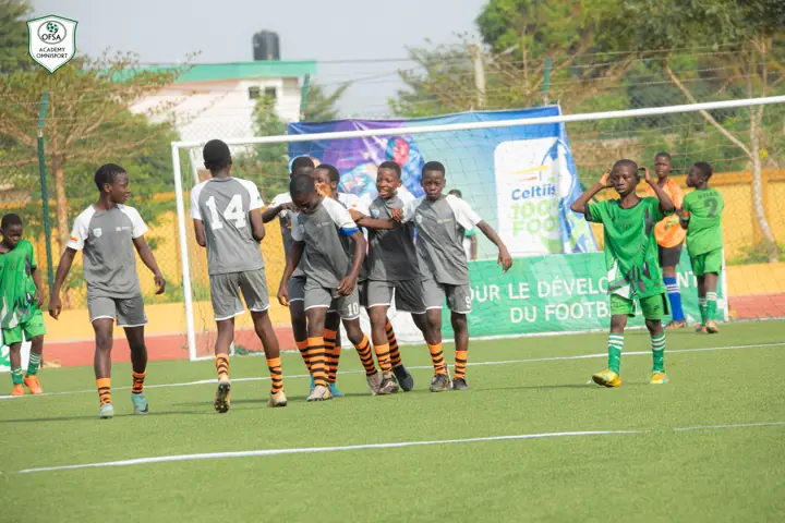 Jeunes joueurs sur le terrain devant une banderole Celtiis